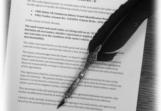 Feather pen laying on a document for Business Law Contracts by Merrill A. Hanson
