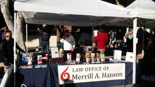 Booth set up with the banner Law Office of Merrill A. Hanson.
