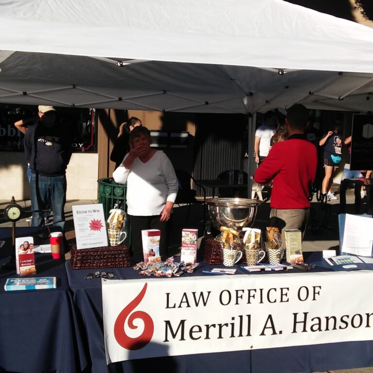 Booth set up with the banner Law Office of Merrill A. Hanson.
