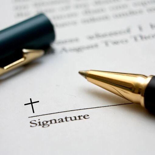 Signature line with a cross and a pen.