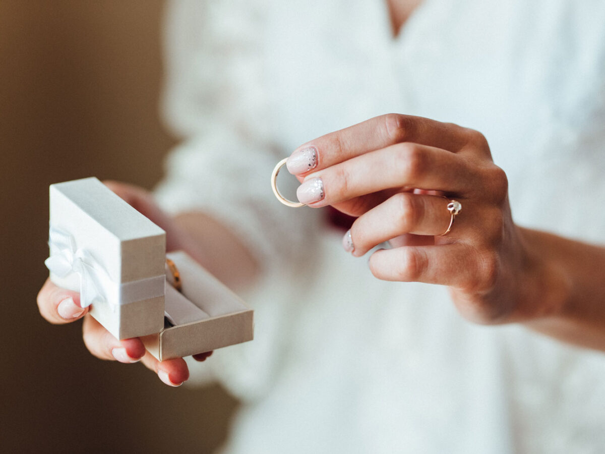 Lady holding a wedding ring.